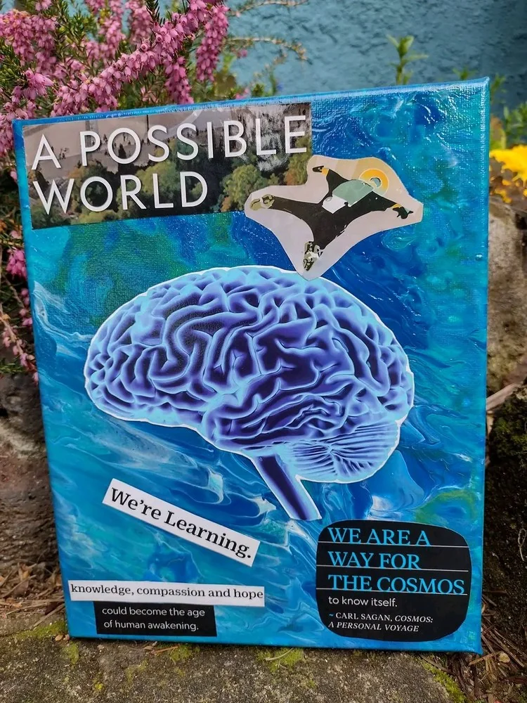 Canvas painted in swirling ocean blues, with a large blue brain at the centre and a skydiver falling above it. Cut-out words read A possible world and We're learning, with a Carl Sagan line about us being a way for the cosmos to know itself.